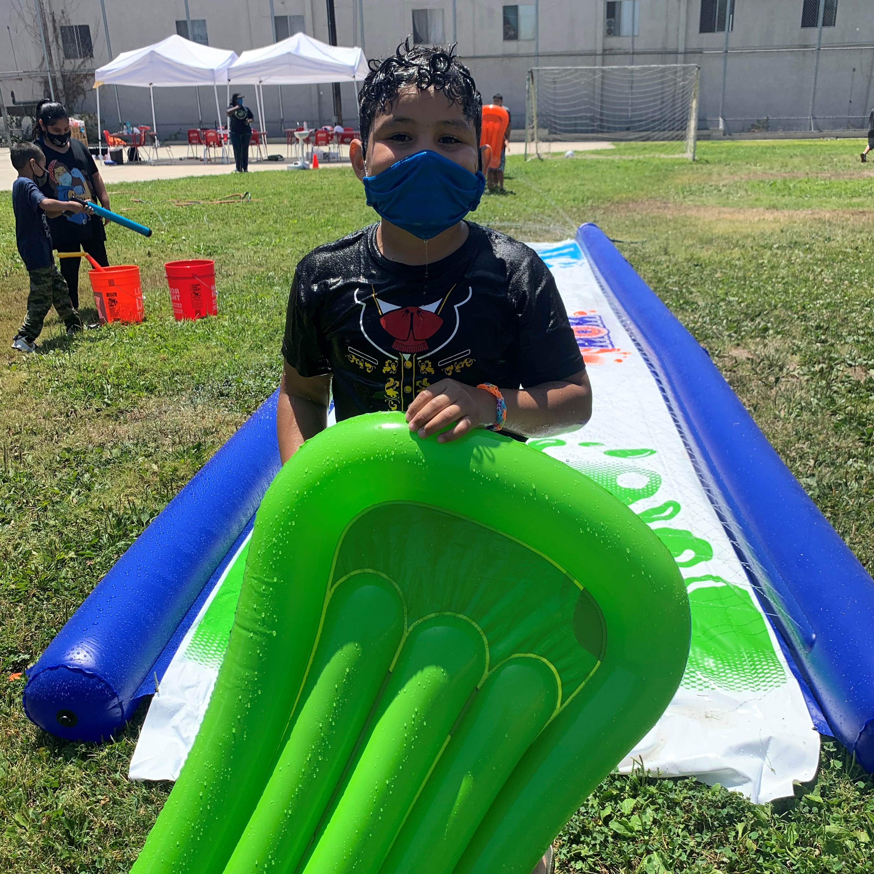 Young boy with air mattress at slip-n-slide
